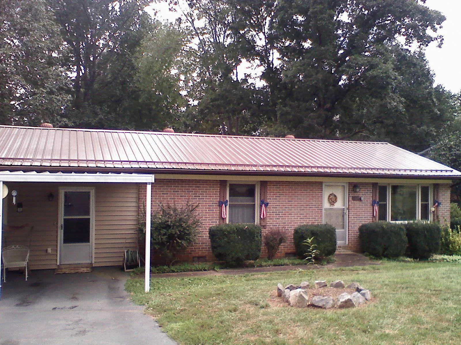 Bronze metal roof and carport on a brick ranch home — Roof Repair work by our crew in Ebony